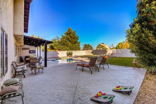 a patio with chairs and a table in a yard at Hidden Gem in the Desert -Gym/Pool/Spa/Games-4BR in Spring Valley