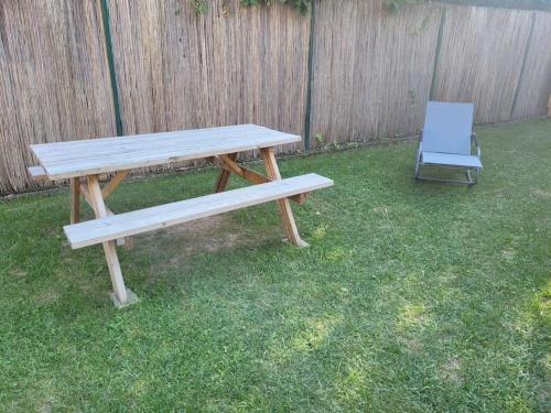 a wooden picnic table and a chair in a yard at L'arche in Muttersholtz