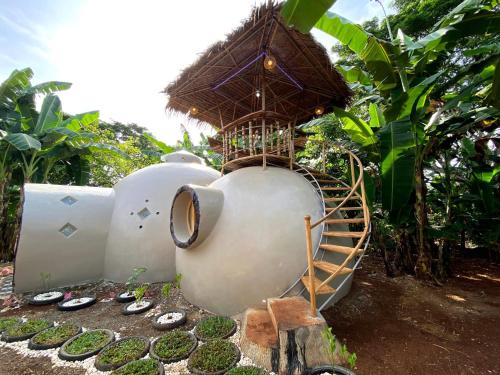 two white tanks with a bird house on top of it at Adorable Dome House in Puerto Princesa City