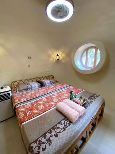 a bedroom with a large bed and a round window at Adorable Dome House in Puerto Princesa City