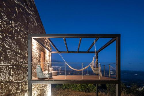 un balcón con una hamaca en el lateral de un edificio en Casa da Moiroa, en Sendim