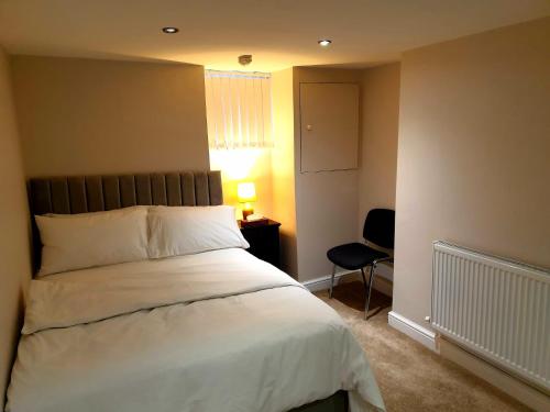 a bedroom with a bed and a lamp and a chair at Elegant 2 bed apartment in Manchester in Manchester