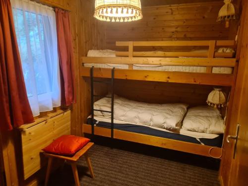 FlumserbergにあるSchwendihöckli - CharmingStayのキャビン内のベッドルーム1室(二段ベッド2組付)