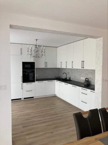 eine Küche mit weißen Schränken und schwarzen Geräten in der Unterkunft Tatranec in Lendak