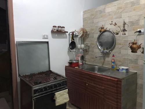 uma pequena cozinha com um fogão e um lavatório em Studio Farida Pyramids View no Cairo