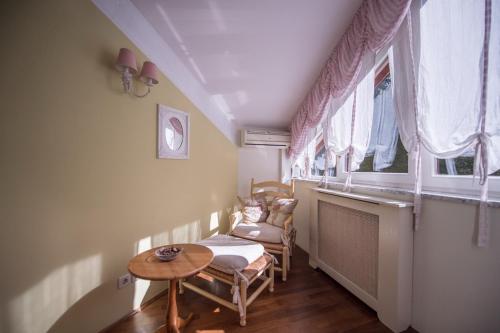 a small room with a table and chairs and windows at Guesthouse Trajbar Team in Zaprešić