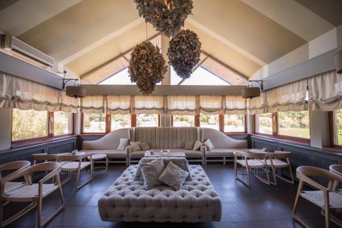 a room with a couch and tables and windows at Guesthouse Trajbar Team in Zaprešić