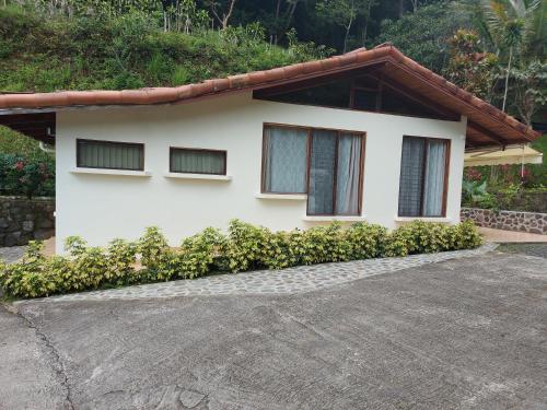 a white house with windows and a driveway at Bungalows Sanlaz in Barrio Jesús