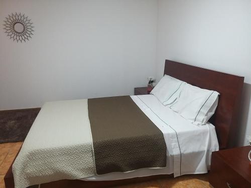 a bedroom with a large bed with a wooden headboard at 2-Bed House - Garden Parking Pets in Viana do Castelo