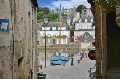 una calle estrecha con un barco azul en un cuerpo de agua en Très bel Appartement avec superbe vue sur le Port de Saint Goustan, en Auray