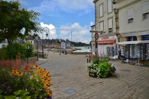 una plaza de la ciudad con flores en una calle de ladrillo en Très bel Appartement avec superbe vue sur le Port de Saint Goustan, en Auray