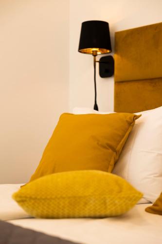 a yellow pillow sitting on a bed with a lamp at Sidra city apartment in Zadar