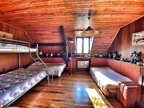 une chambre avec deux lits et un plafond en bois dans l'établissement Maison de village avec terrasse et jardin Saint Urcize, à Saint-Urcize