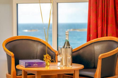 a bottle of wine on a table with two chairs at Portrush Atlantic Hotel in Portrush