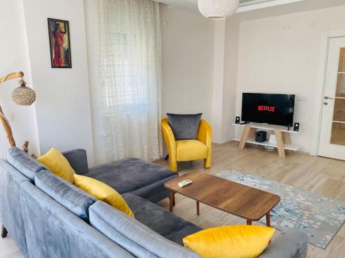 uma sala de estar com um sofá azul e uma mesa em Aether Flats No7,Old Town, Beach, Central, Netflix em Antalya
