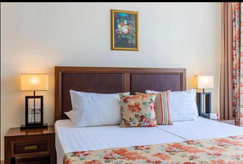 a bedroom with a large bed with pillows and two lamps at Sunset Resort Apartament C3 - 22 in Pomorie
