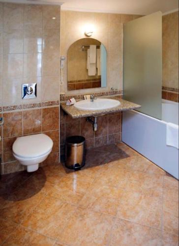 a bathroom with a sink and a toilet and a mirror at Sunset Resort Apartament C3 - 22 in Pomorie