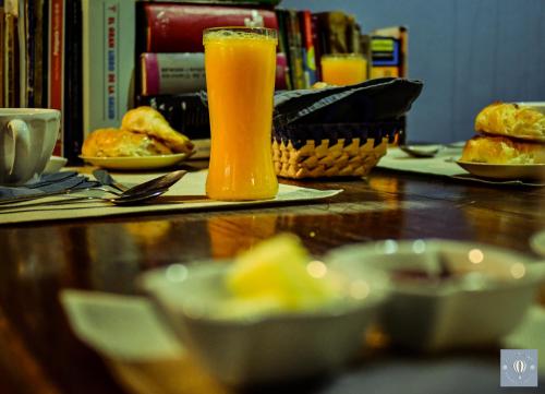 a glass of orange juice sitting on a table at VagaMundo Hostel Carhue in Carhué