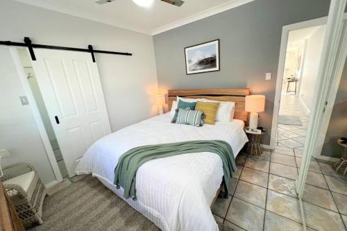 um quarto com uma grande cama branca num quarto em Ally’s Umina Oasis, pet-friendly spa coastal oasis em Umina