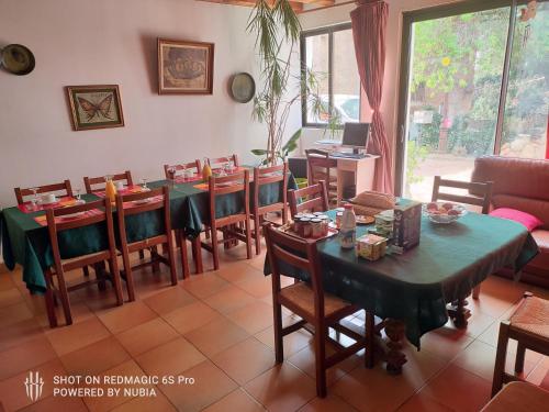 uma sala de jantar com mesa e cadeiras e um quarto com em L'Orca di San Gavinu em Figari