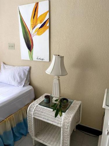 a bedroom with a bed and a table with a lamp at Lush Tropical apartment located in a 4-star resort in Runaway Bay