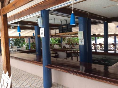 een restaurant met blauwe zuilen en een spiegel bij Lush Tropical apartment located in a 4-star resort in Runaway Bay