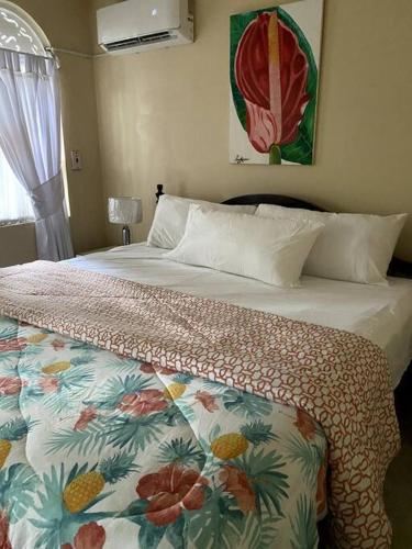 a bedroom with a bed with a floral bedspread on it at Lush Tropical apartment located in a 4-star resort in Runaway Bay