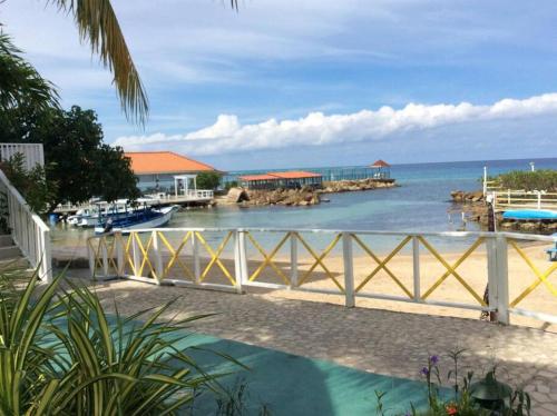 a view of the ocean from a beach with a fence at Lush Tropical apartment located in a 4-star resort in Runaway Bay