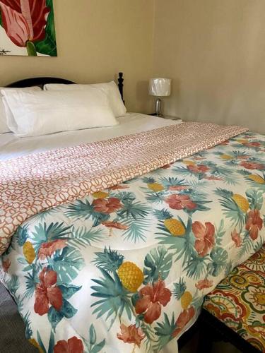 a bedroom with a bed with a floral comforter at Lush Tropical apartment located in a 4-star resort in Runaway Bay