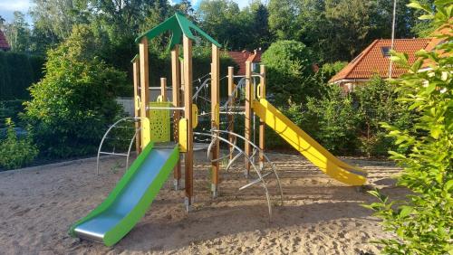 um parque infantil com escorrega na areia em Apartament Rejs em Ostróda