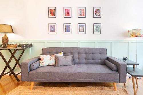 a couch in a living room with pictures on the wall at Alfama Patio Apartments in Lisbon