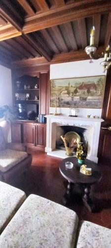 a living room with a fireplace and a table at Moradia entre o Mar e a Ria in Gafanha da Nazaré