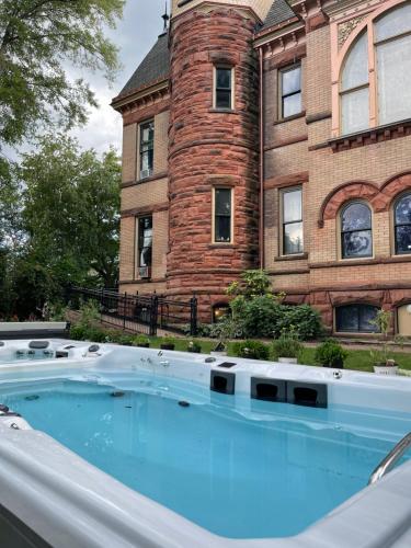 a swimming pool in front of a brick building at Henderson Castle Inn in Kalamazoo
