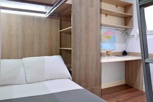 a small bedroom with a bed and a book shelf at Luxury at its best beach condo in Palaio Faliro in Athens