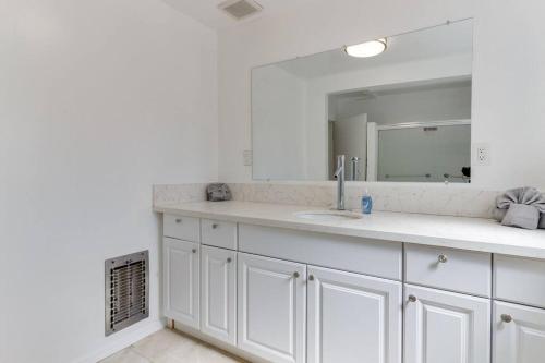 a white bathroom with a sink and a mirror at 3 bedroom Mid-Wilshire Charmer near Downtown in Los Angeles