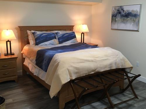 a bedroom with a large bed with two lamps at Lakeview Gardens B&B in Peachland