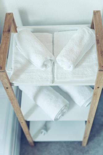 - une étagère dans un réfrigérateur rempli de serviettes blanches dans l'établissement Le Bohême Chic Superbe studio + parking Free, à Dunkerque