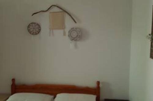 1 dormitorio con 1 cama y 2 relojes en la pared en Το σπίτι της Ελένης en Vlakhiá