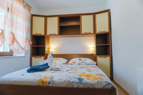- une chambre avec un lit doté d'une tête de lit en bois et d'étagères dans l'établissement Apartments by the sea Lumbarda, Korcula - 9325, à Lumbarda