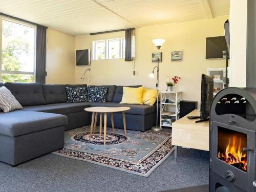 een woonkamer met een bank en een open haard bij 6 person holiday home in Nibe in Nibe