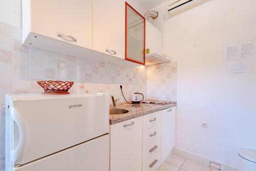 una piccola cucina con lavandino e frigorifero di Apartments by the sea Tri Zala, Korcula - 9317 a Korčula
