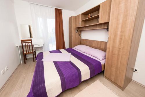a small bedroom with a bed and a chair at Apartments by the sea Prozurska Luka, Mljet - 9446 in Prožura
