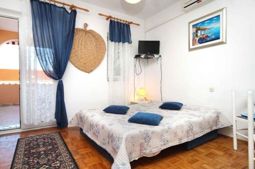 ein Schlafzimmer mit einem Bett mit blauen Kissen darauf in der Unterkunft Apartments and rooms with a swimming pool Novalja, Pag - 9334 in Novalja