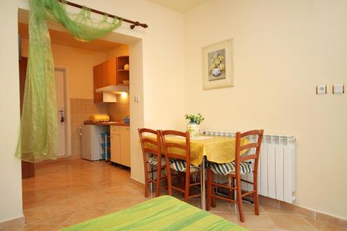 eine Küche und ein Esszimmer mit einem Tisch und Stühlen in der Unterkunft Apartments and rooms with a swimming pool Novalja, Pag - 9334 in Novalja