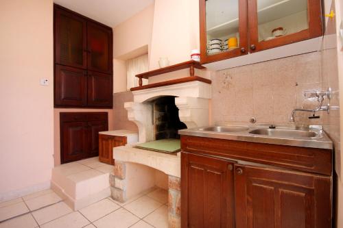 uma cozinha com um lavatório e uma lareira em Apartments by the sea Karbuni, Korcula - 9308 em Prizba