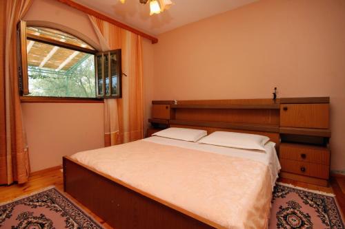 sypialnia z dużym łóżkiem i oknem w obiekcie Apartments by the sea Karbuni, Korcula - 9308 w mieście Prižba