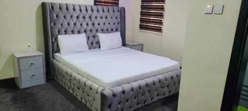 a bed with a padded headboard in a room at Premium 3 Bedroom Villa Upscale Alagbaka Area in Akure
