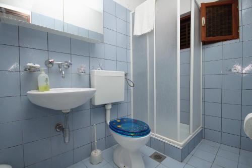 La salle de bains est pourvue de carrelage bleu, de toilettes et d'un lavabo. dans l'établissement Apartments by the sea Zavalatica, Korcula - 9315, à Zavalatica