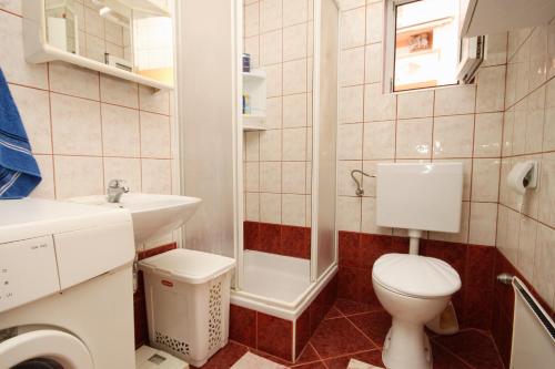a small bathroom with a toilet and a sink at Apartments by the sea Vidalici, Pag - 9415 in Kustići