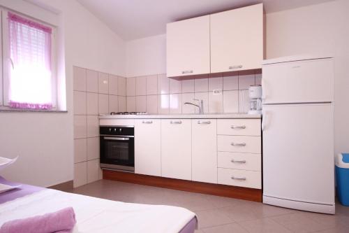 kuchnia z białymi szafkami i białą lodówką w obiekcie Apartments with a parking space Poljica, Trogir - 10010 w Marinie